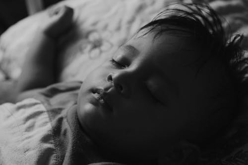 Free Sleeping little boy lying on bed Stock Photo