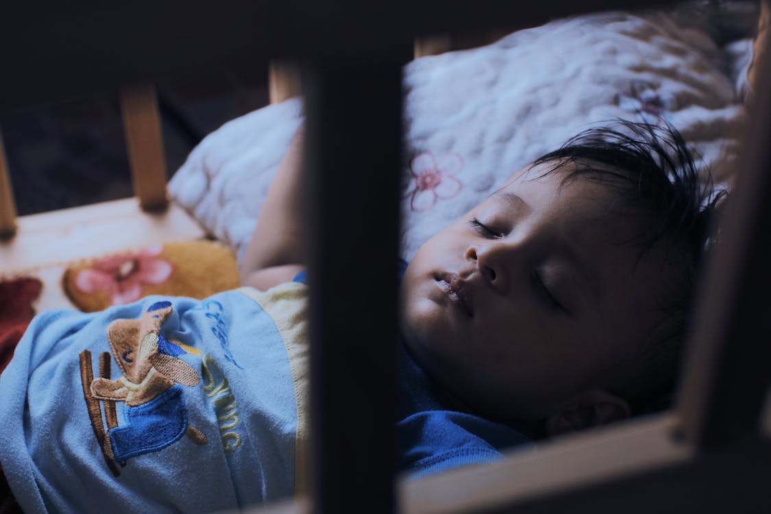 Free Cute ethnic boy sleeping in crib Stock Photo