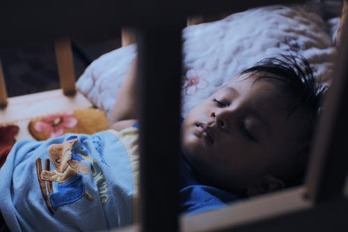 Free Cute ethnic boy sleeping in crib Stock Photo