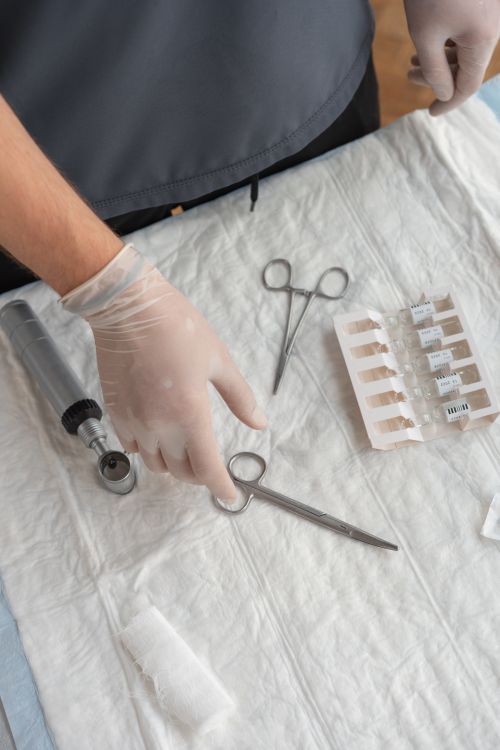 Free Top view of medical tools on a white cloth, hand in glove arranging scissors. Stock Photo