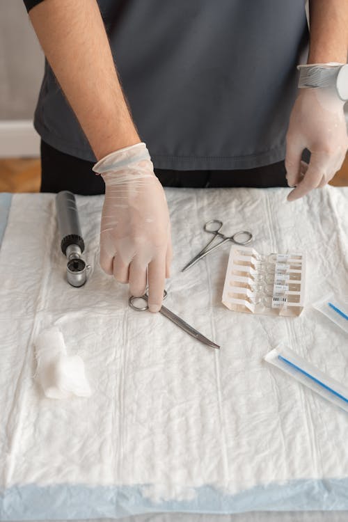 Person in White Long Sleeve Shirt Holding Silver and Black Hand Tool