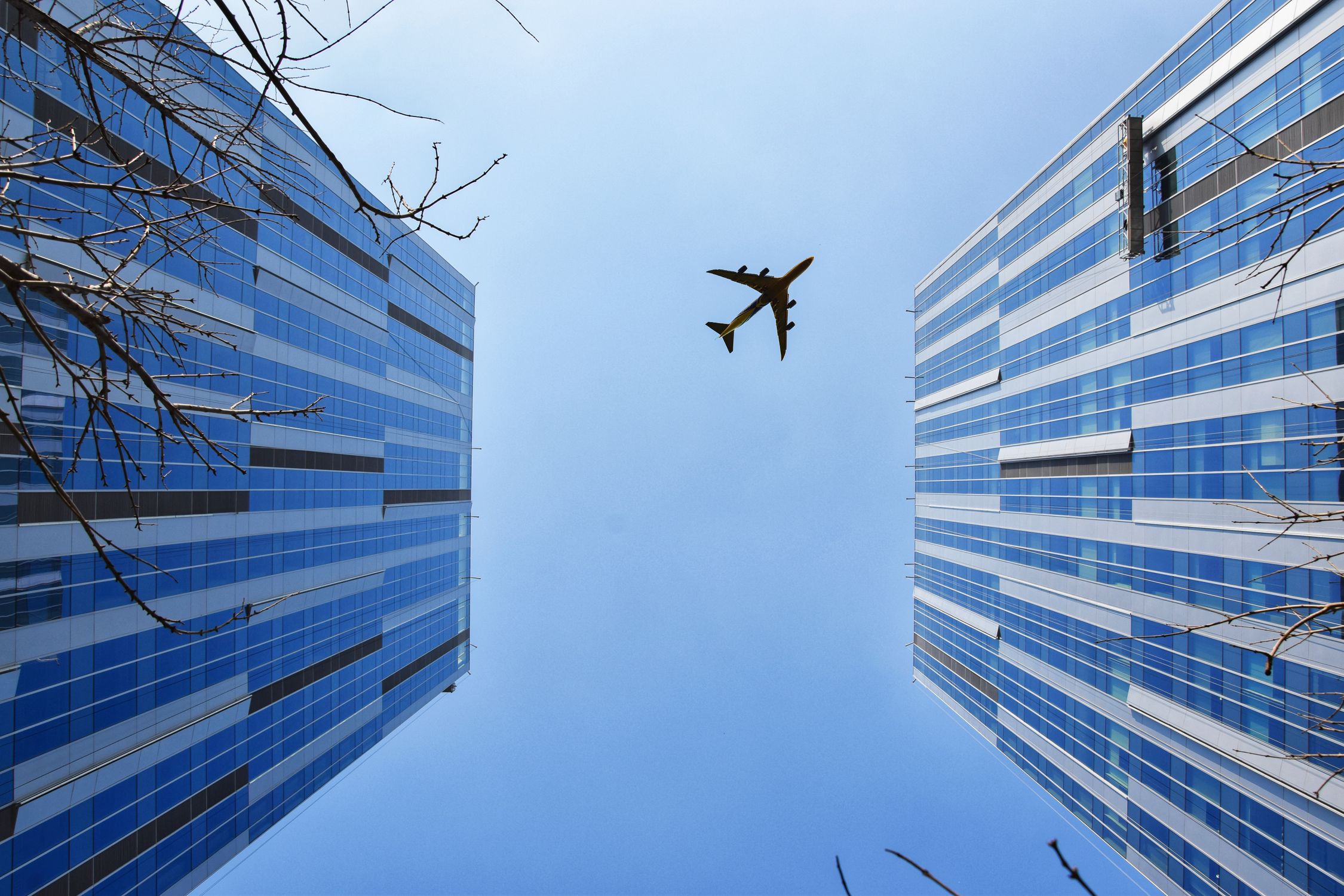 Airplane Near Blue and Grey Building · Free Stock Photo