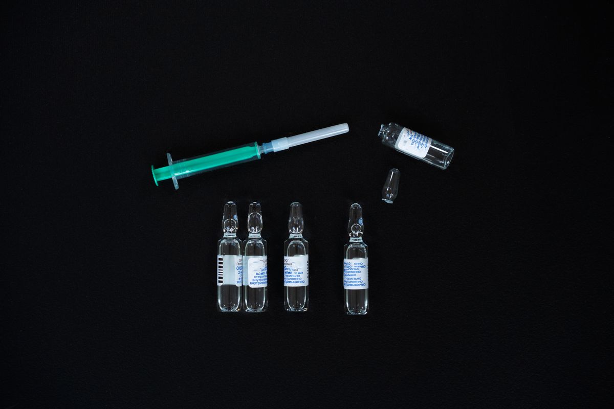 Sealed medical vials and syringes arranged on a dark surface, representing prescription growth hormone therapy used only for diagnosed deficiency in Virginia Beach