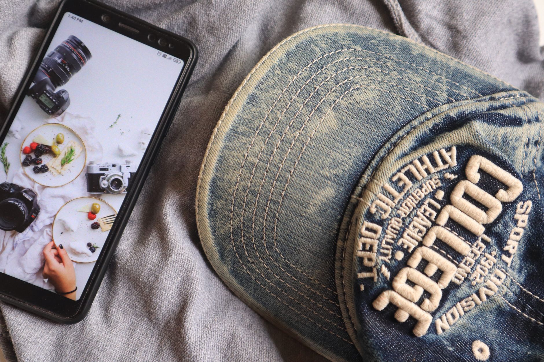 Stylish flat lay featuring a denim cap, smartphone, and fashion items for a modern look.