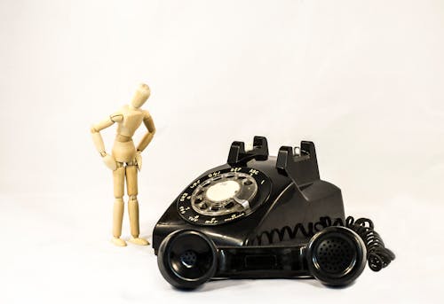 Free Black Rotary Telephone Beside Beige Manekin Stock Photo