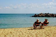 Senior couple enjoying a relaxing day on Varna beach with serene ocean views.