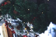 特写镜头捕捉了装饰圣诞花环上的松果、浆果和灯光，尽显节日气氛