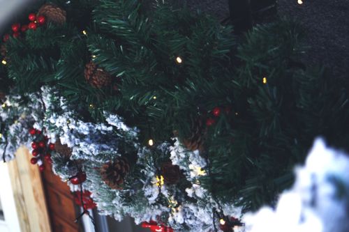 Free Close-up of a decorated Christmas garland with pinecones, berries, and lights, capturing the festive spirit. Stock Photo