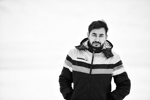 这张黑白肖像中，一位身着冬季夹克的男子展现出风格与自信