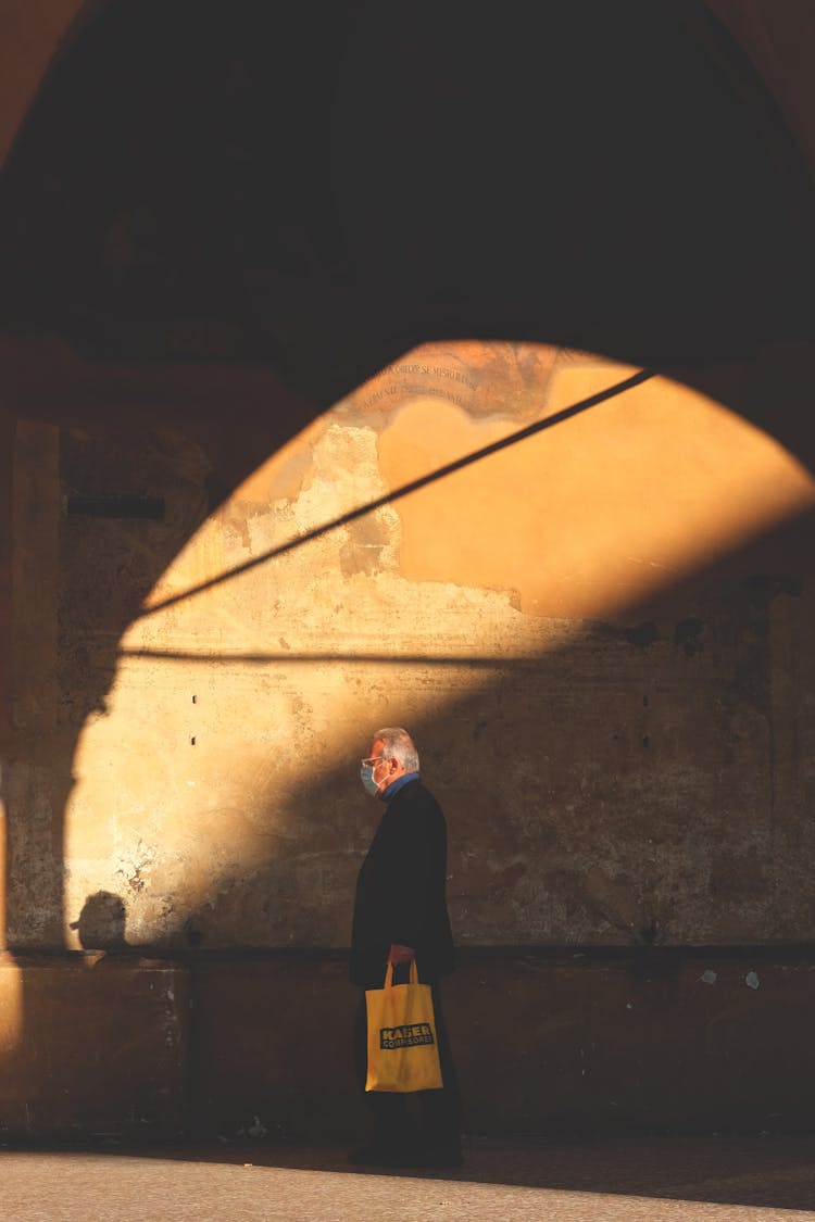 Man In Mask Walking With Bag