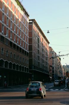City street with cars and historic buildings in early evening light.