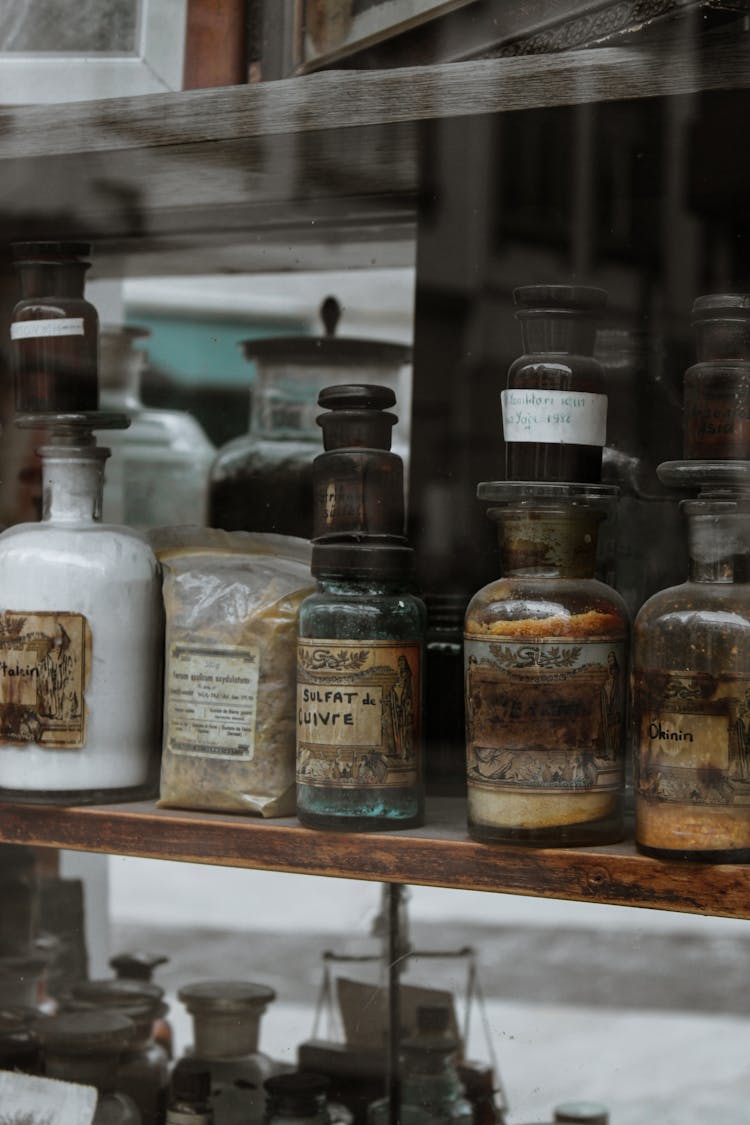 Assorted Bottles On Brown Wooden Shelf