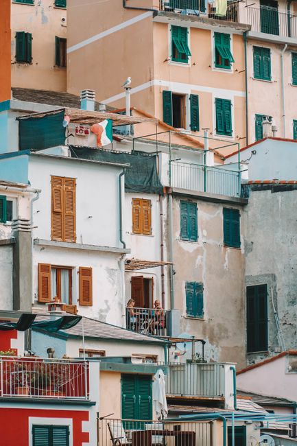 Colorful Ligurian buildings with balconies in Italy, showcasing European architecture.