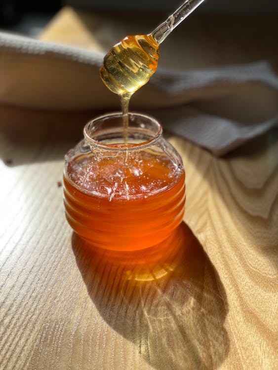 Close-Up Shot of a Glass Jar with Honey