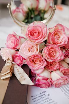 Pink roses with a gift box and mirror reflection, creating a romantic and elegant setting.