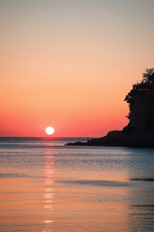 Free Silhouette of Rock Formation on Sea during Sunset Stock Photo