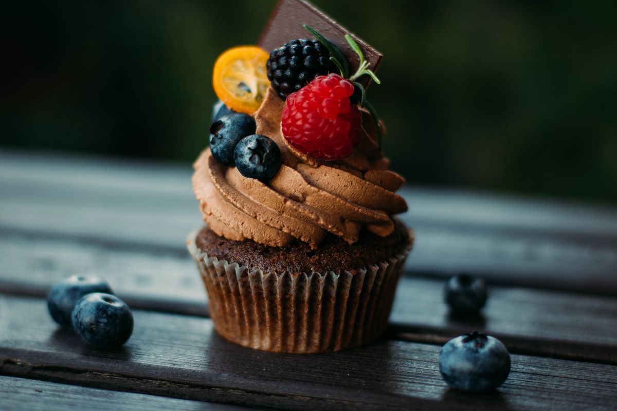 A mouthwatering chocolate cupcake topped with fresh berries and chocolate. Perfect dessert for sweet lovers.