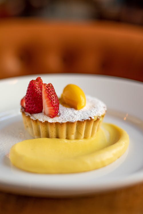 Free Soft focus of delicious tart with pieces of fruits and smear of custard sauce placed on plate Stock Photo