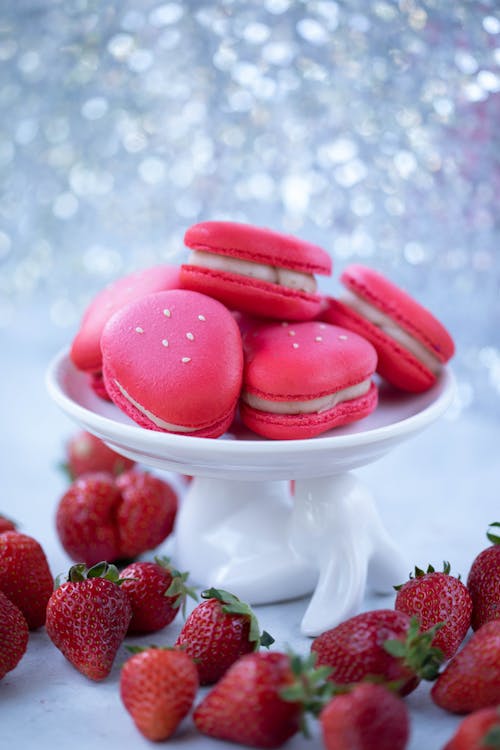 Macaroons and strawberries near glittering wall