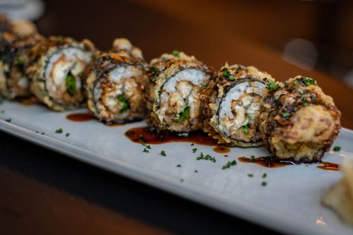 Free Closeup of tasty sushi sprinkled with herbs in soy sauce placed on white dish Stock Photo