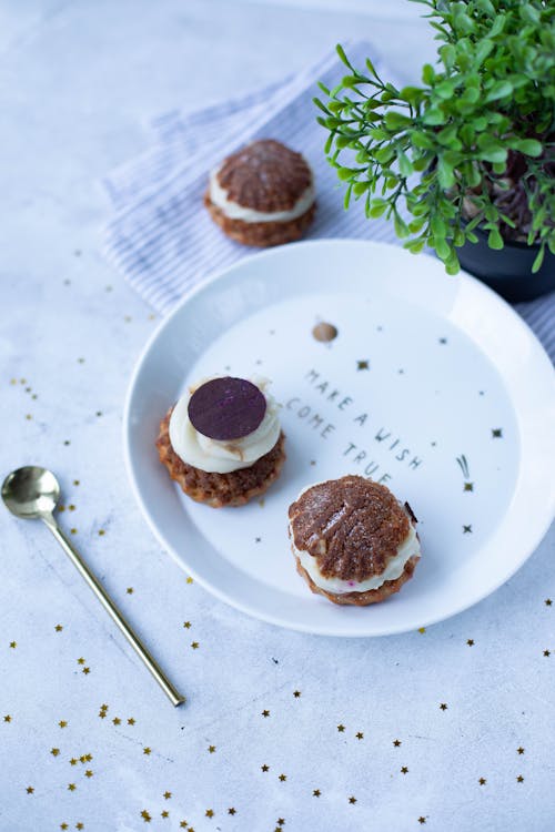 Choux au craquelin pastries on plate near spoon and potted plant