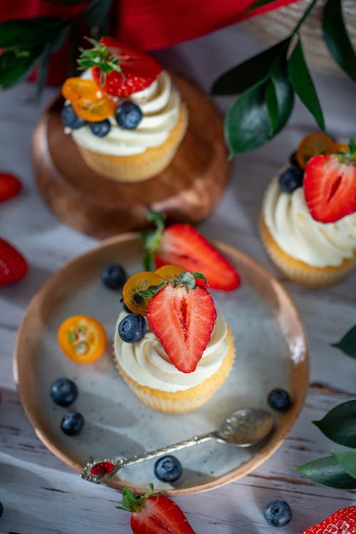 Cupcakes with cream decorated with appetizing blueberries and strawberries