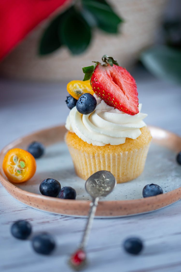 Cupcake With Cream Decorated With Fresh Strawberry And Blueberries