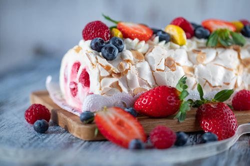 Free Tasty fresh sugar ice cream cake with fresh blueberries placed on timber board on blurred background Stock Photo