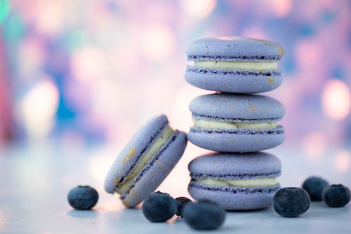 Free Gentle purple macaroons with white delicate cream near fresh ripe blueberries on blurred background Stock Photo