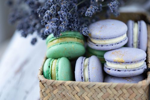 Free Heap of many tasty sweet macaroons under blooming gentle lavender on blurred background Stock Photo
