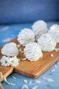 From above of tasty sweet marshmallow zephyr placed on wooden cutting board on table in daytime