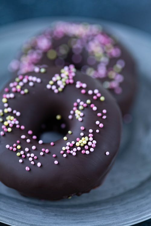Delicious chocolate doughnuts placed on plate