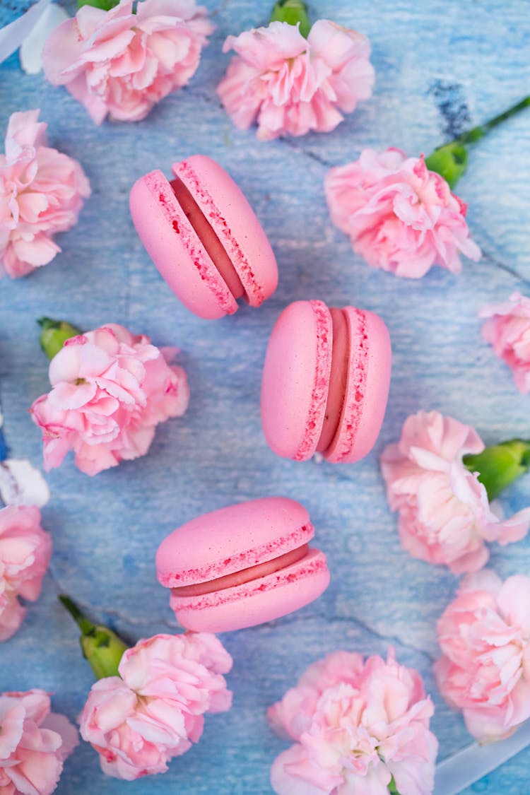 Pink Macaroons Placed Among Carnations On Table