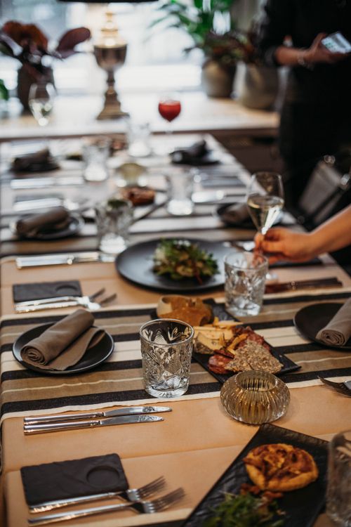 Free Table setting with glassware placed near plates with napkins and cutlery on table with delicious food in modern light restaurant Stock Photo