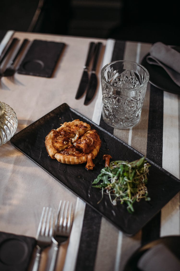 Tasty Quiche On Plate With Greens In Restaurant