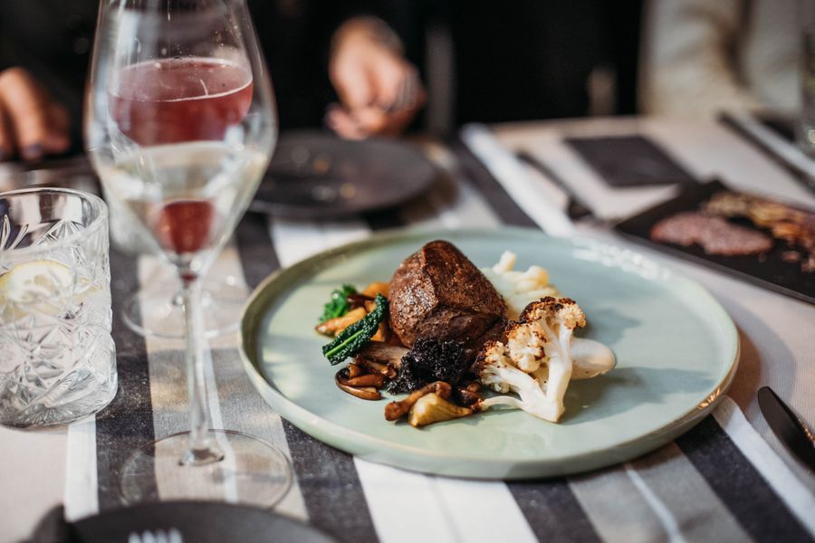 A sliced steak beside a glass of red wine