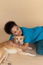 Woman in Blue Long Sleeve Shirt Hugging Brown Short Coated Dog