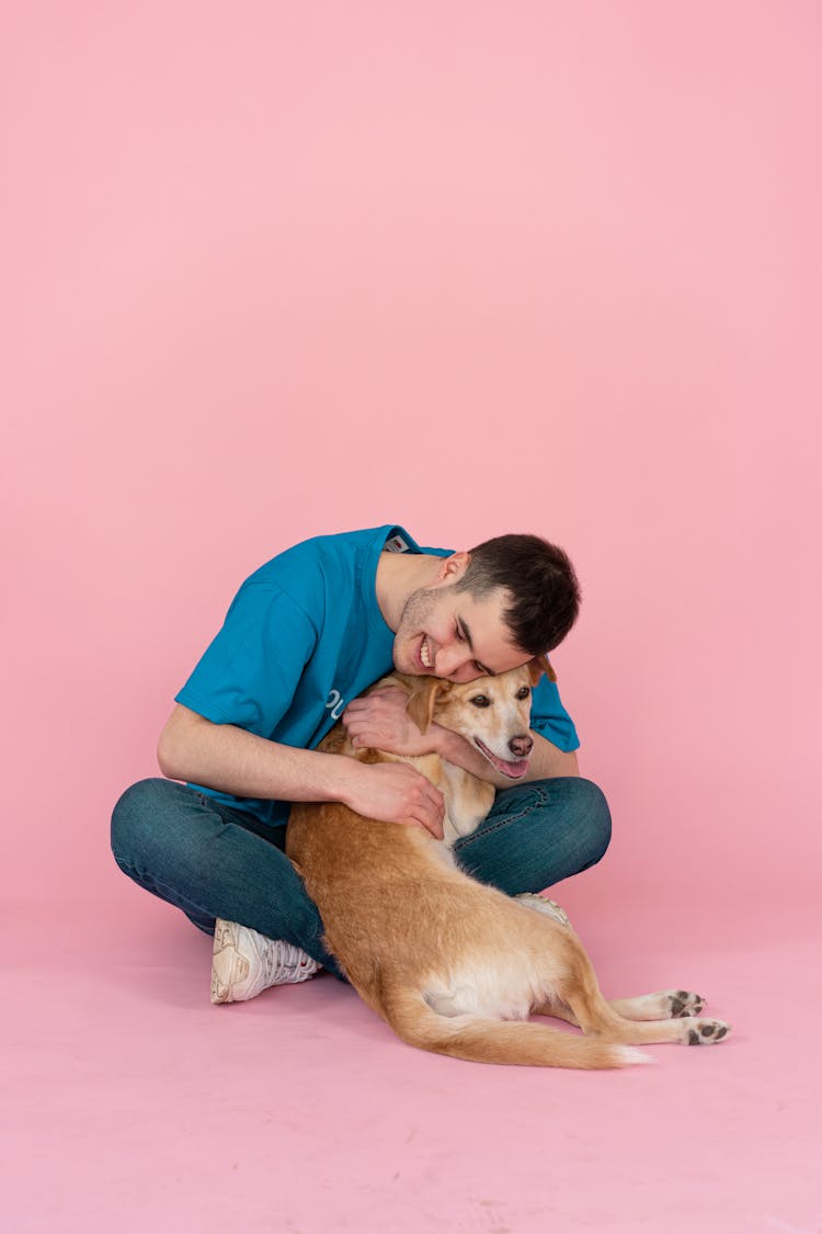 A Man In Blue Shirt A Brown Dog