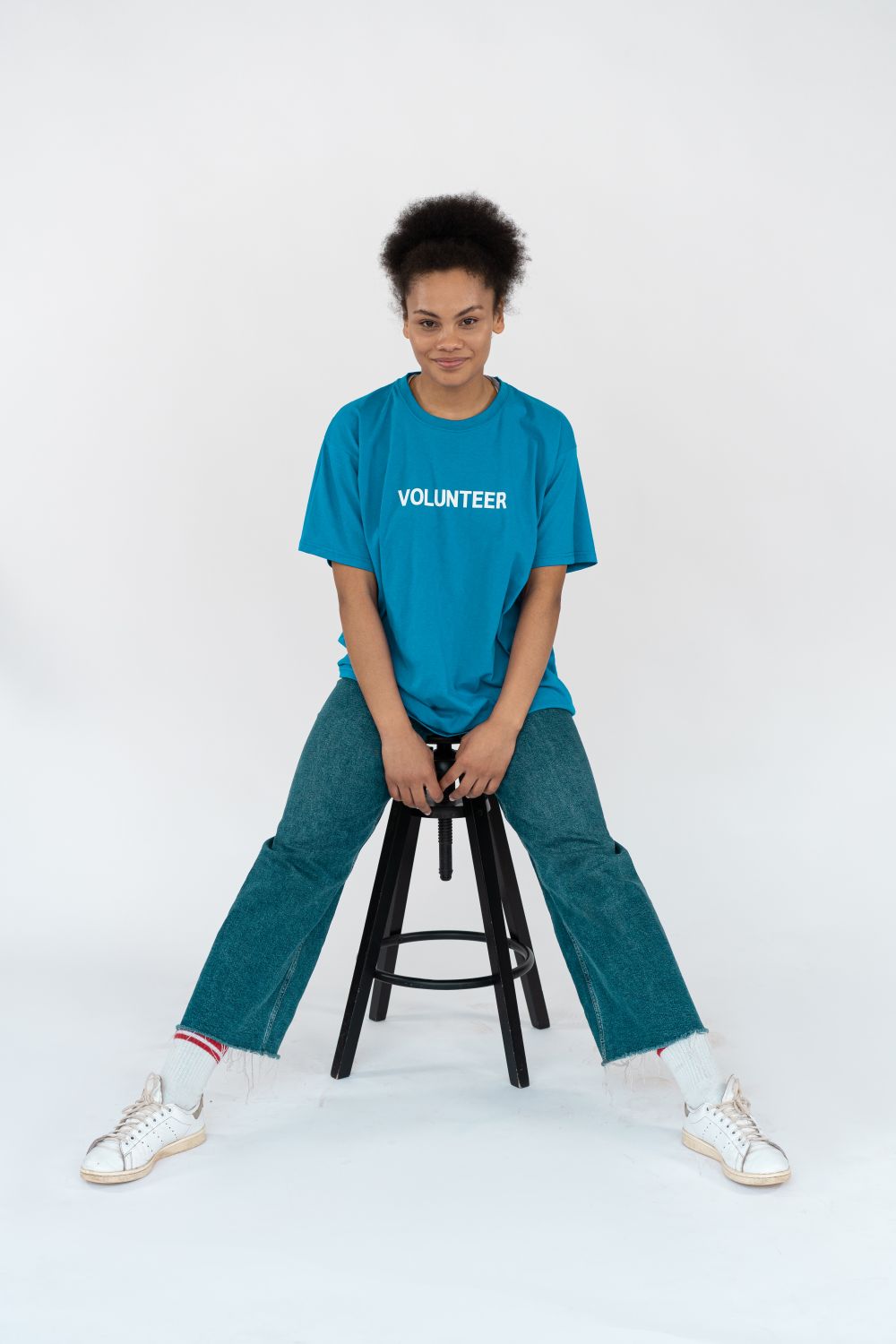 A Female Volunteer in Blue Shirt Sitting on a Chair · Free Stock Photo