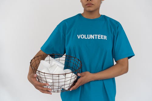 A Person in Blue Shirt Holding a Metal Basket 