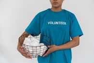 Man in Blue Crew Neck T-shirt Holding White and Black Bird Cage
