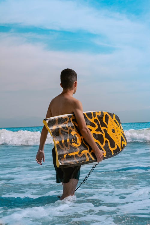 A Man Carrying a Surfboard at the Beach