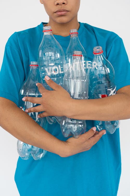 A Person Blue Shirt Holding Plastic Bottles