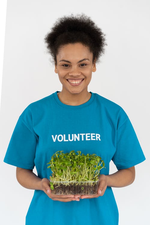 A Woman in Blue Shirt Holding Plants
