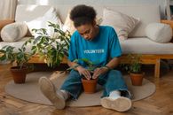 Woman in Blue Crew Neck T-shirt and Blue Denim Jeans Sitting on Brown Sofa