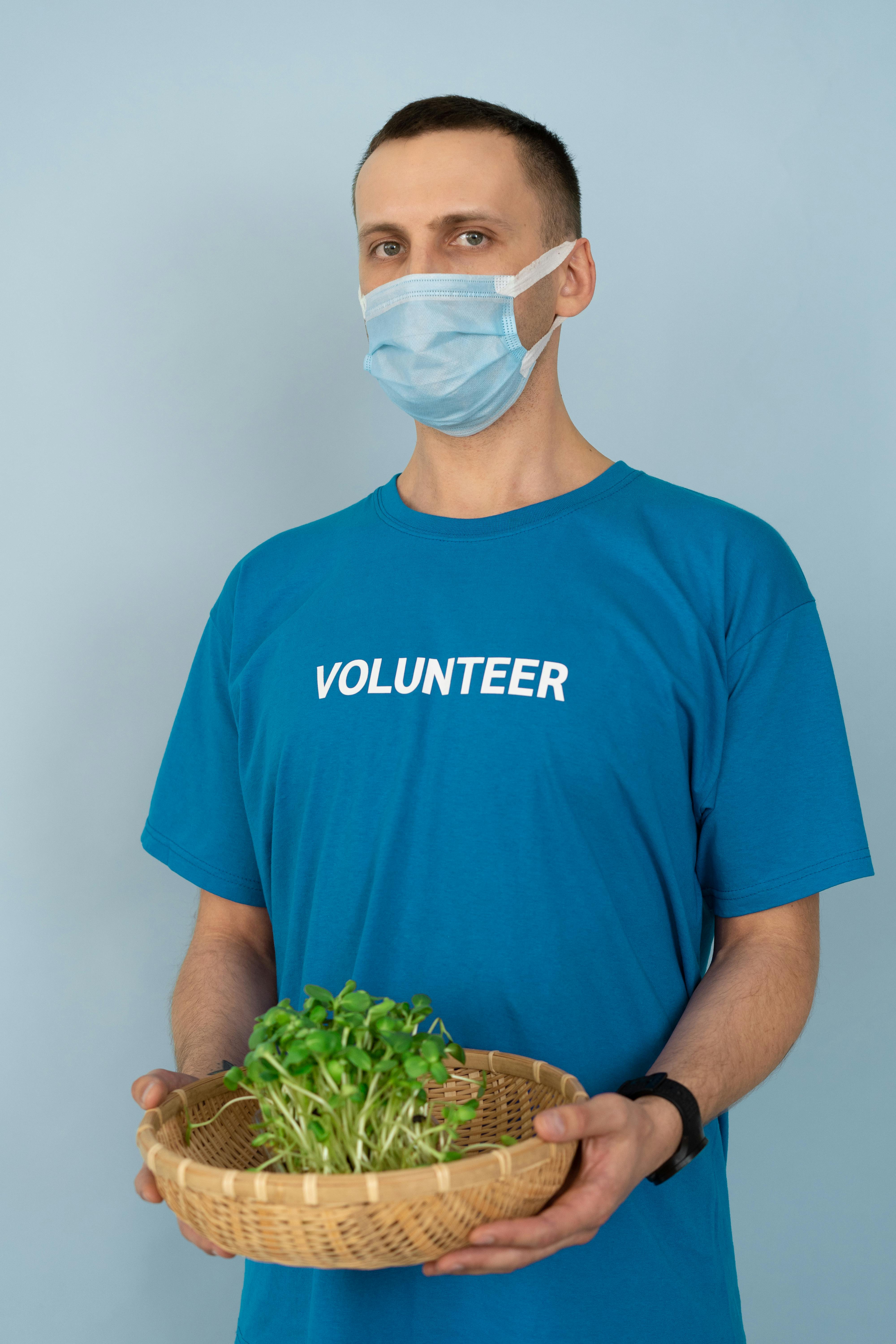 man in blue crew neck t shirt wearing white face mask