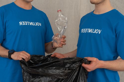 Free Two young volunteers collecting plastic for recycling, promoting environmental conservation. Stock Photo