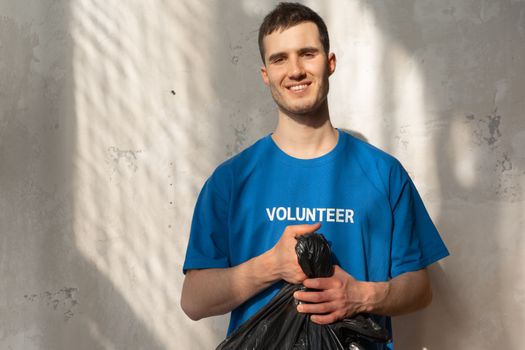 Smiling volunteer holding a garbage bag during a community cleanup effort. Bright and positive environmental action.