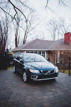 A stylish SUV parked in front of a suburban house during autumn.