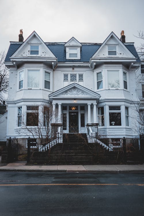 Facade of classic residential white house with staircase and pediment